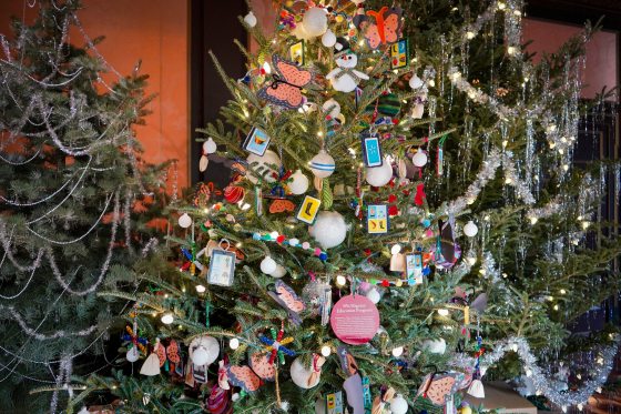 A Christmas tree decorated with ornaments made by young children.